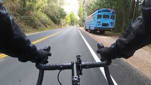 Passing a blue bus, framed by handlebars